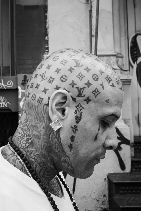 NYC street portrait of a man with Louis Vuitton logo tattood on his head taken during a photo workshop