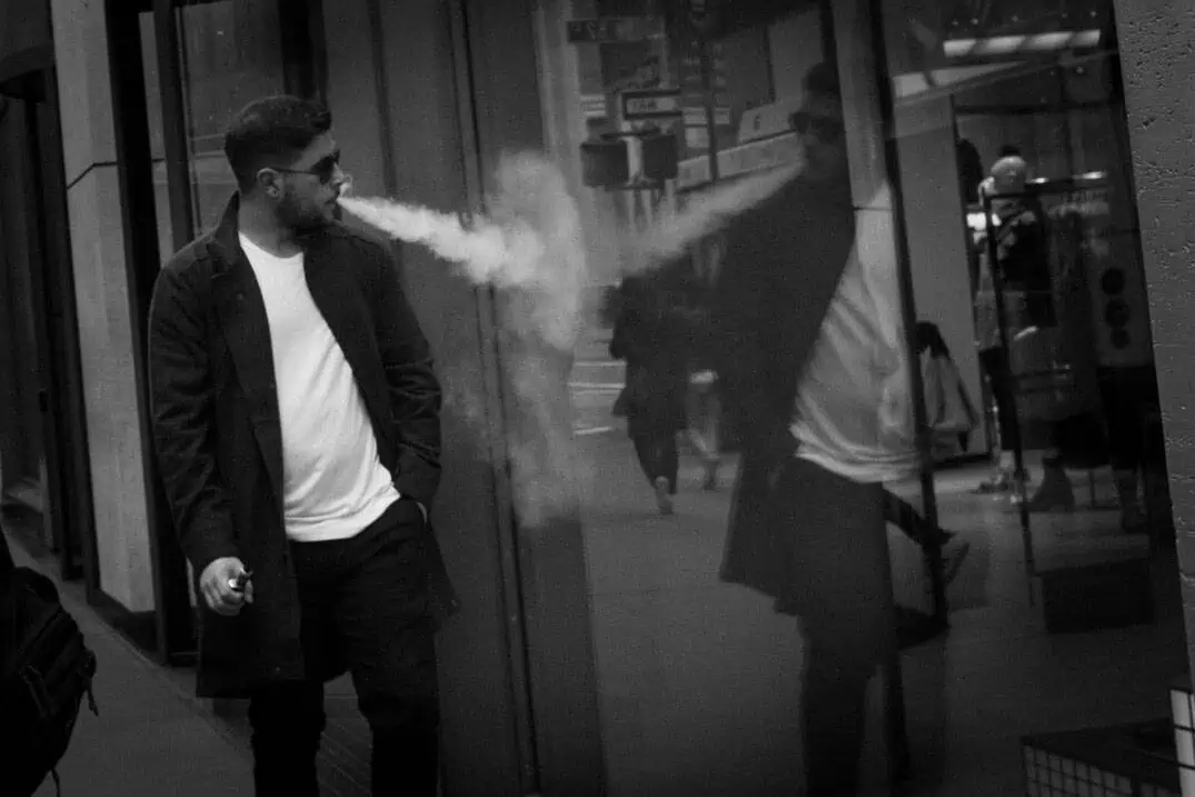 New York street photography workshop - Man smoking vape looking at reflection